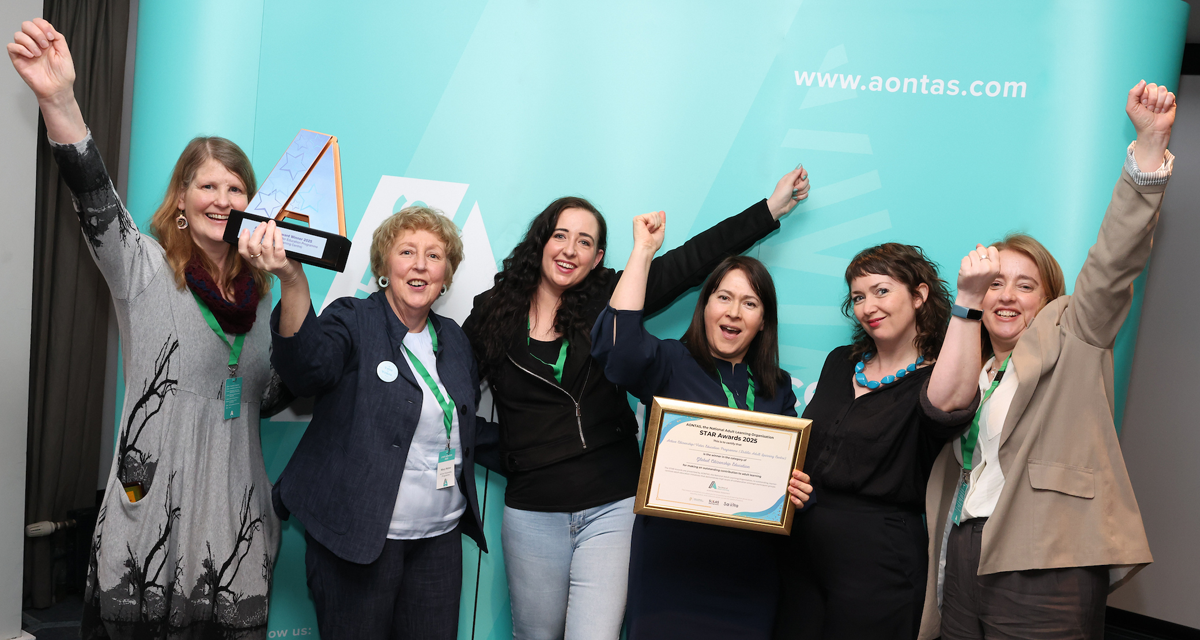 Staff from Dublin Adult Learning Centre celebrate with their STAR Award in Croke Park in front of an AONTAS backdrop