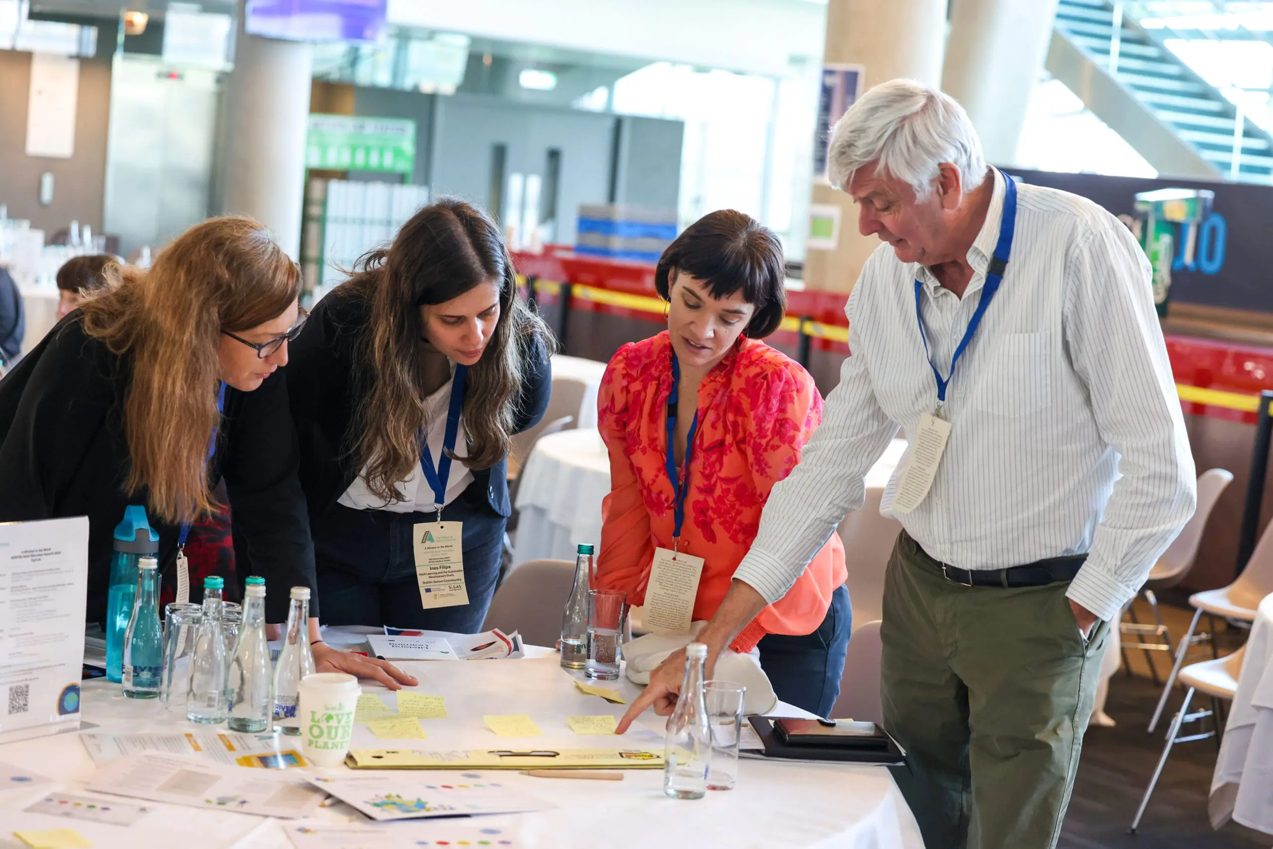 Learners gather at table to discuss documents