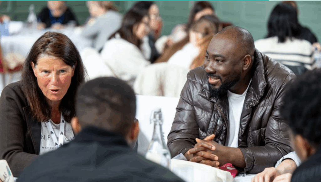 Adult learners discussing and laughing at a round table